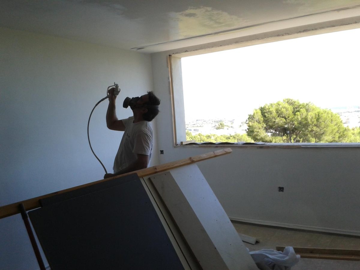 Pintor de Kromatics aplicando pintura a pistola en una vivienda de Mallorca