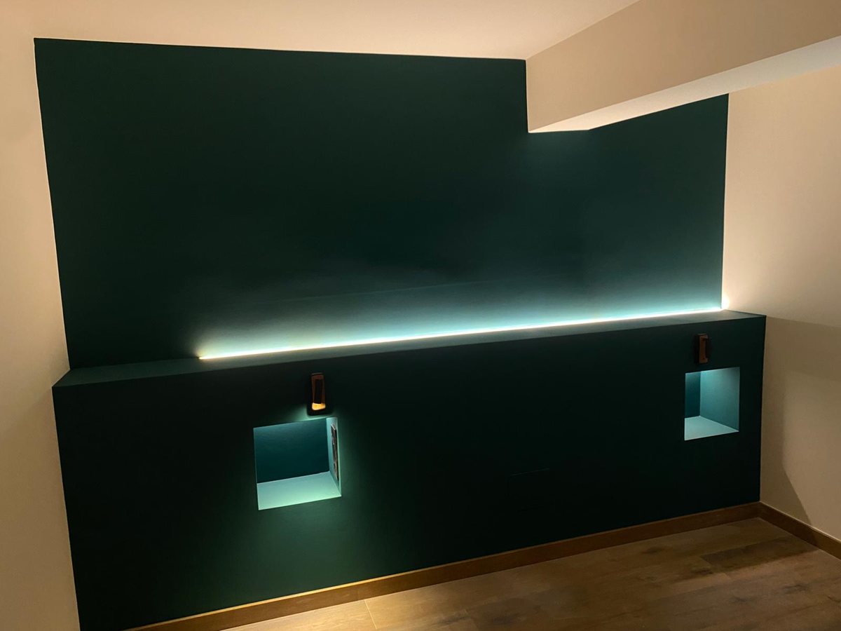 Pared verde con iluminación LED y hornacinas